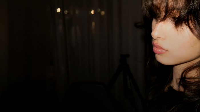 Side profile of a young woman in dark room