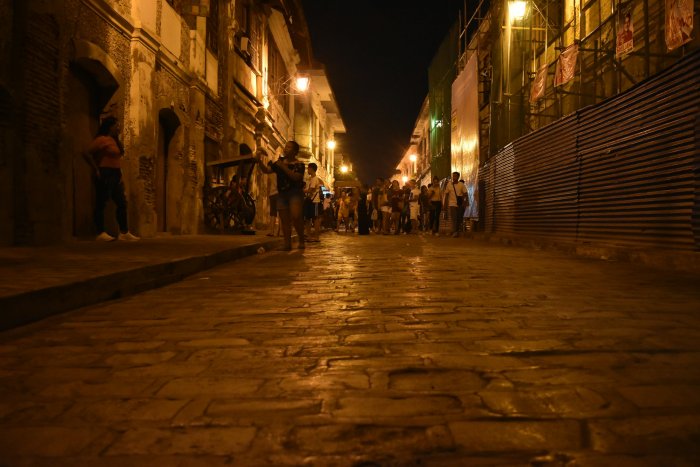 Cobblestone street at night with people walking
