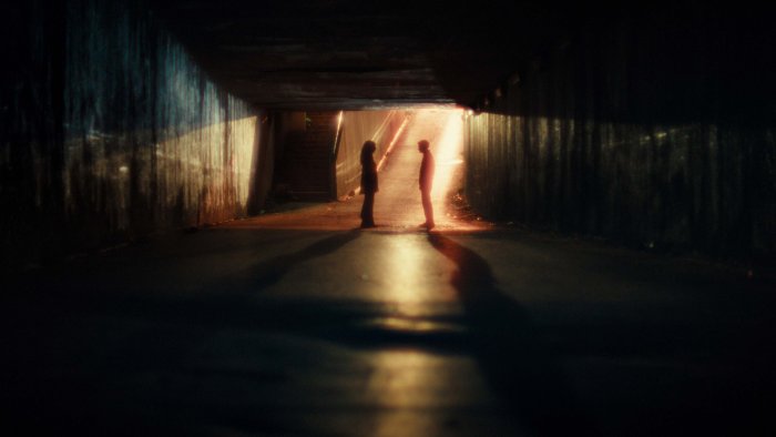 Silhouetted couple in a dark tunnel