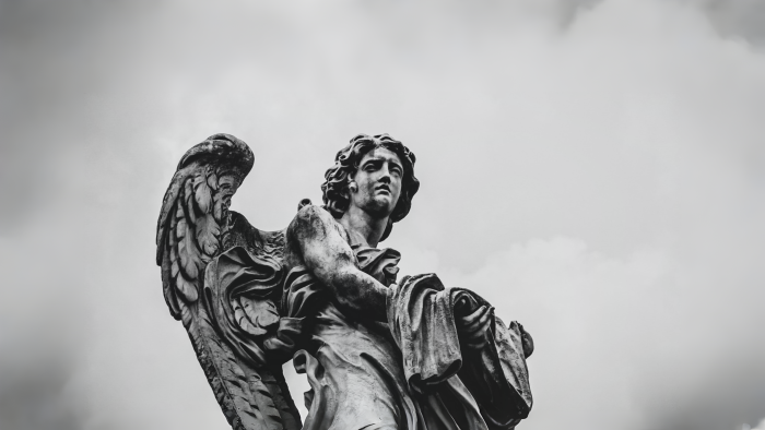 Stone angel statue against a cloudy sky