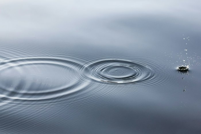 Concentric ripples and water splash on smooth surface