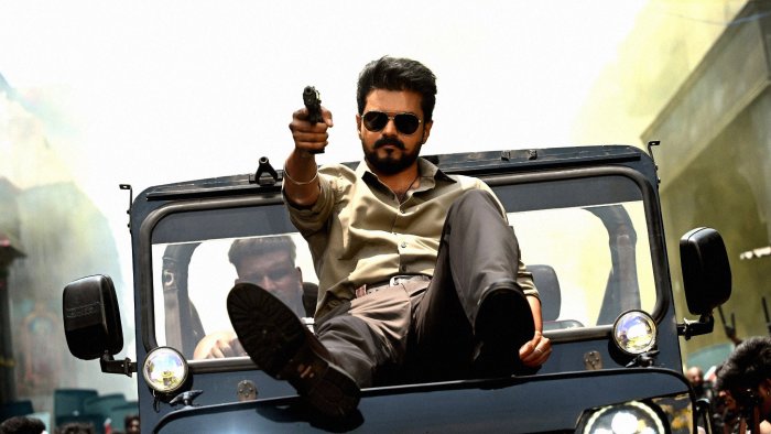 Actor Vijay pointing a gun from a jeep