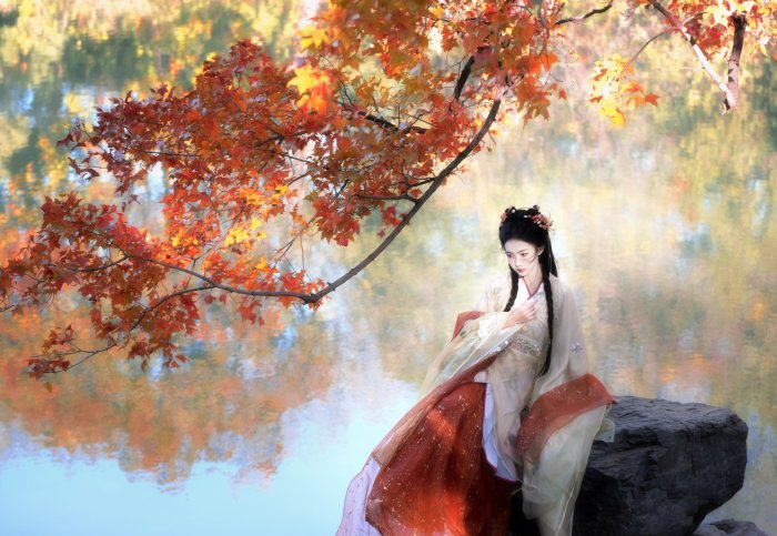 Woman in Traditional Hanfu Under Autumn Maple Leaves
