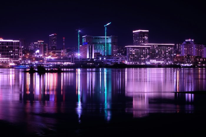 City skyline illuminated at night with water reflection