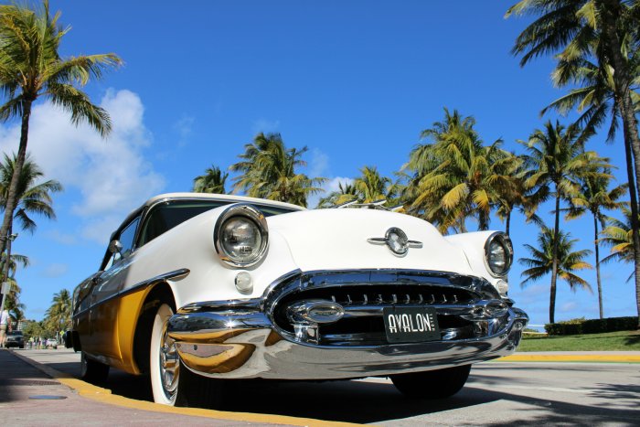 Classic White and Yellow Car Parked Under Palm Trees