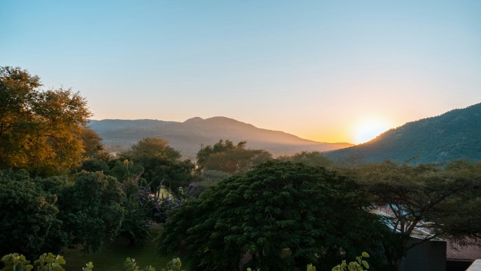 Sunset over mountains and lush green trees