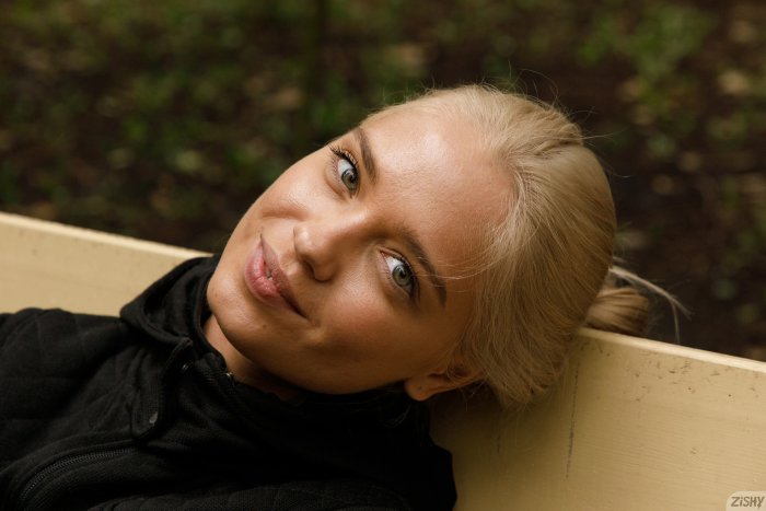 Blonde Woman Leaning Back on a Wooden Bench