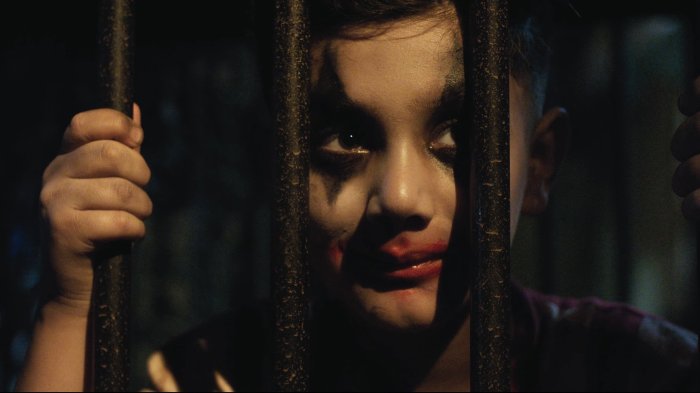 Child with Joker Makeup Behind Bars in Toxic Movie