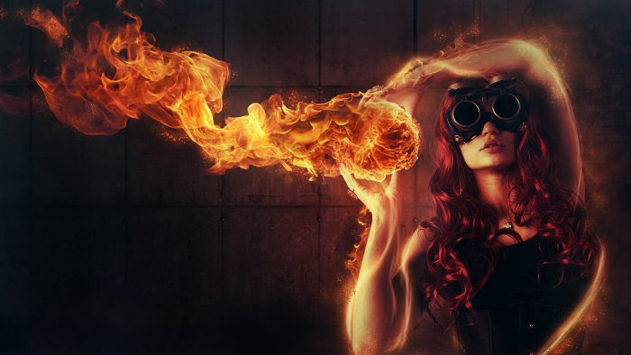 Red-haired woman with goggles manipulating a fireball