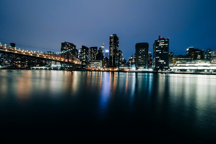 City Skyline and Bridge at Night with Water Reflection