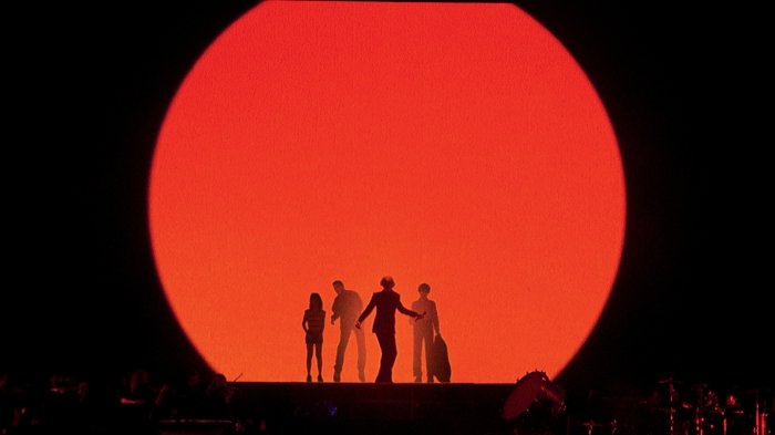 Pulp band members performing in front of a giant red circle