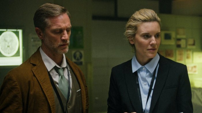 Two detectives in a dimly lit room