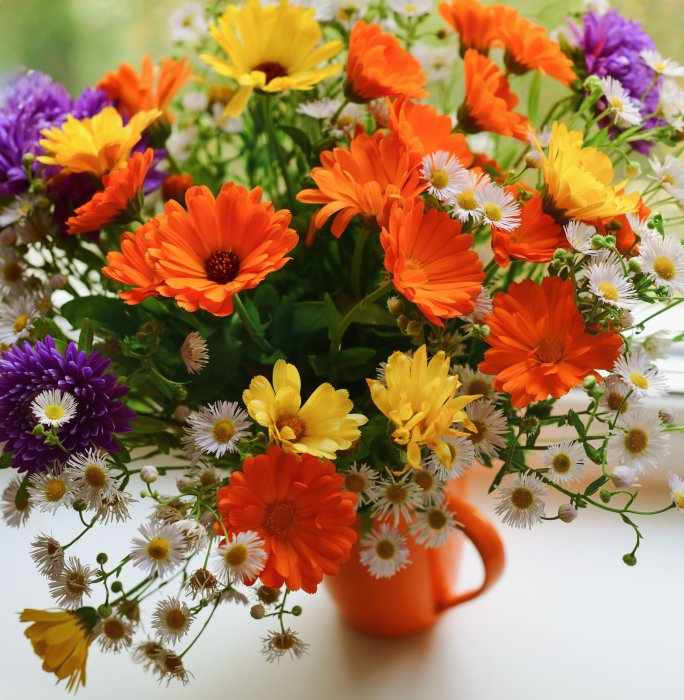 Colorful bouquet of flowers in an orange mug