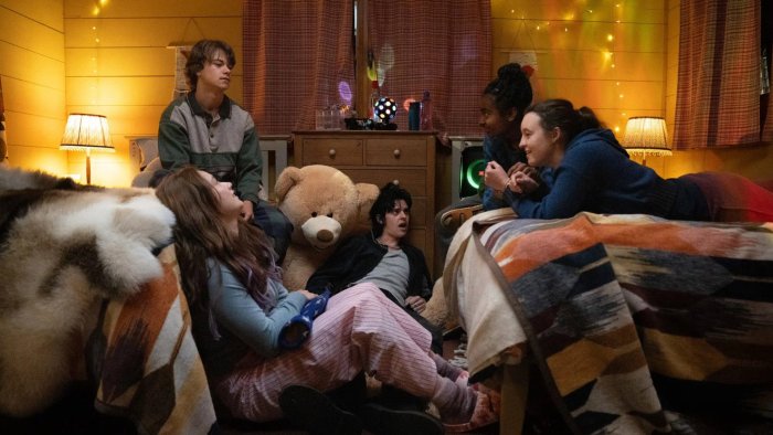 Group of teens in a bedroom with a teddy bear