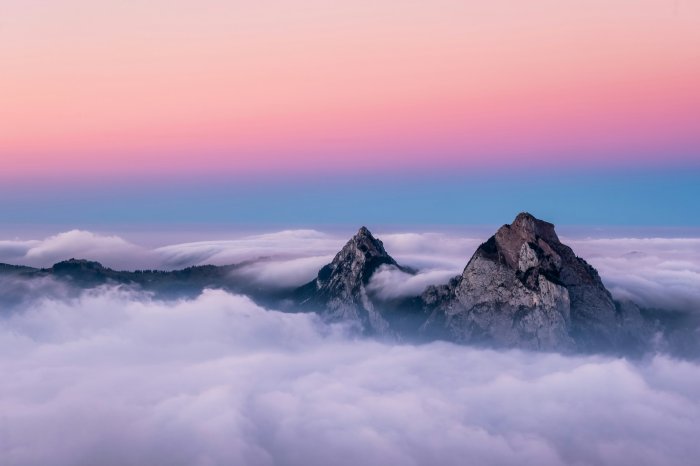 Mountain peaks above clouds at sunset