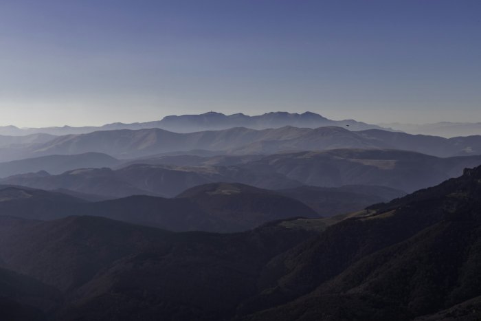 Layered mountain ranges under a clear blue sky