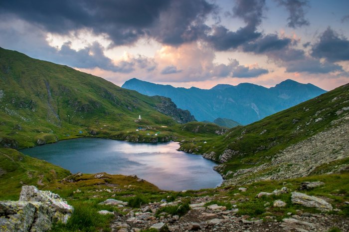 Mountain lake with tents and distant peaks