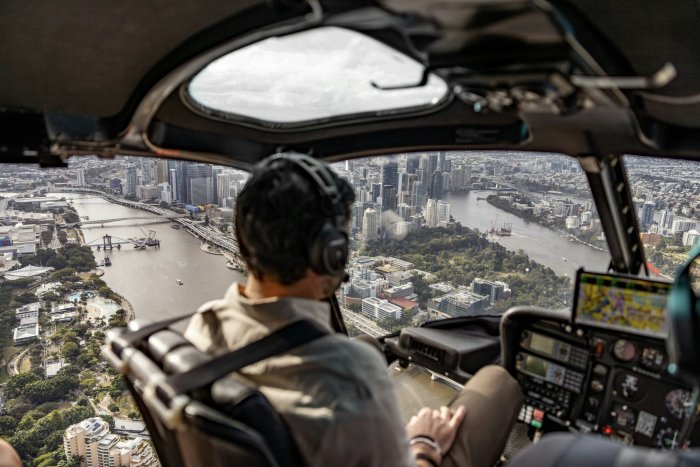 Pilot flying helicopter over Brisbane city