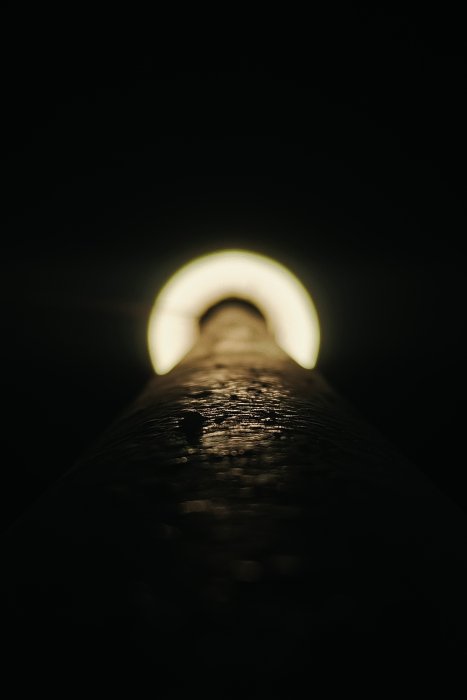 Close-up of a textured pipe with light at the end