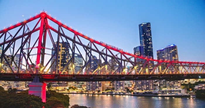 Story Bridge illuminated red at night with city skyline