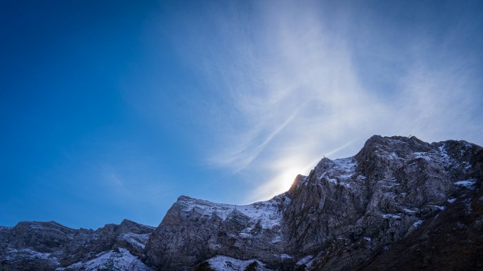 Snow-covered mountain peak against a bright blue sky