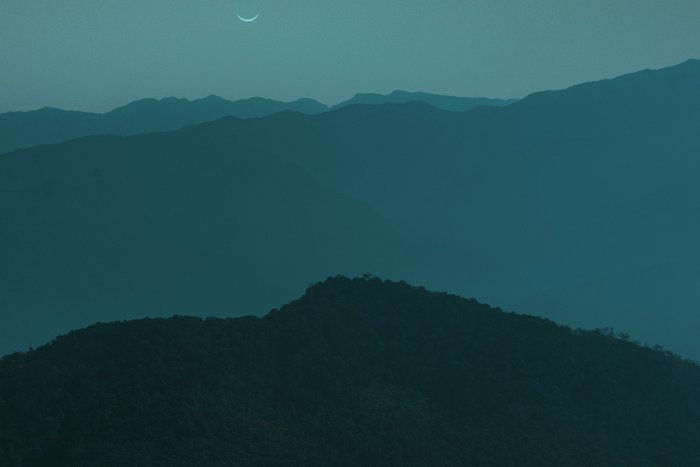 Crescent Moon Over Misty Mountain Ranges