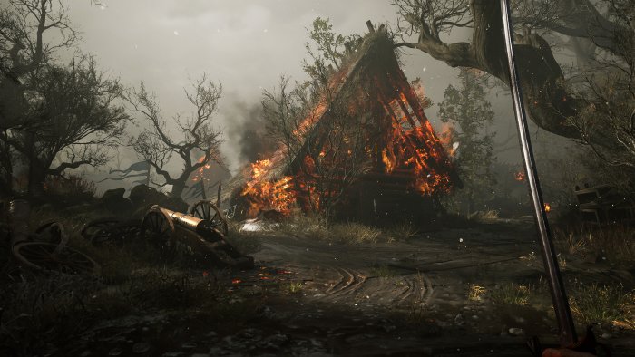 Burning cabin and cannon in a dark forest