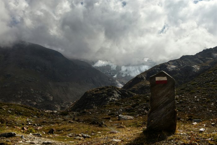 Stone marker in a cloudy mountain landscape with glacier