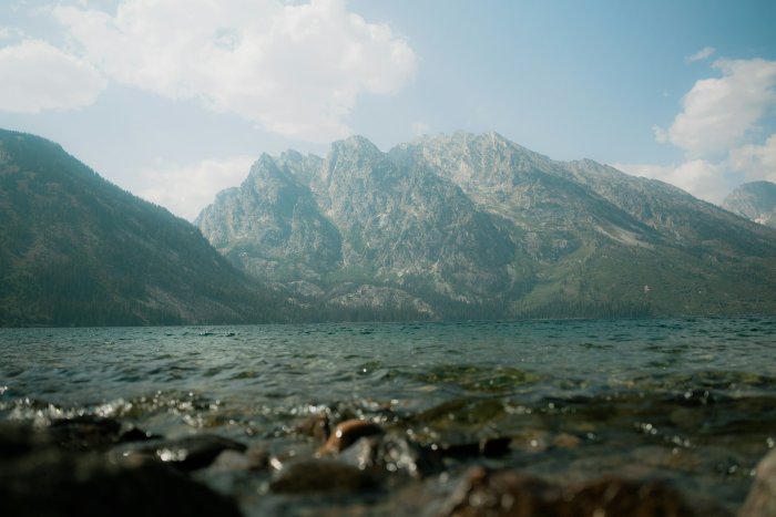 Rocky shore with a lake and mountains beyond