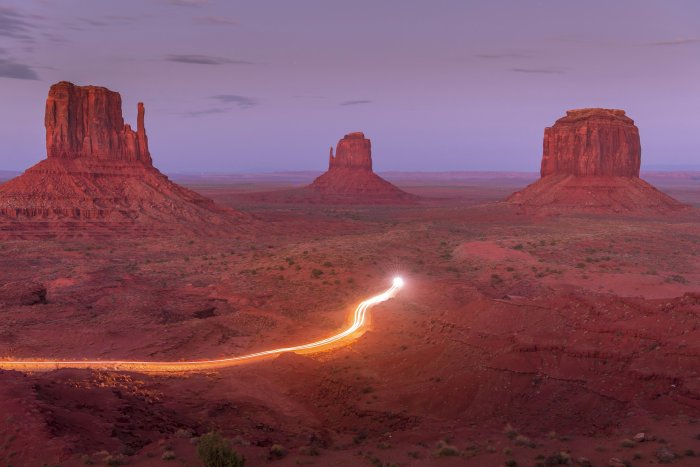 Monument Valley at twilight with car light trails