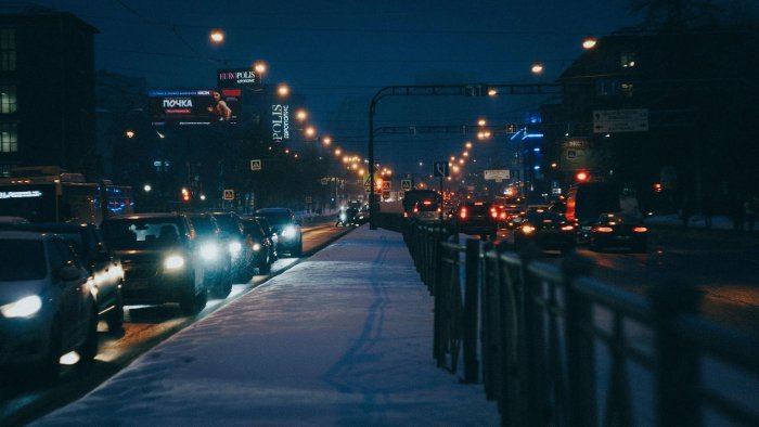 Snowy city street at night with traffic