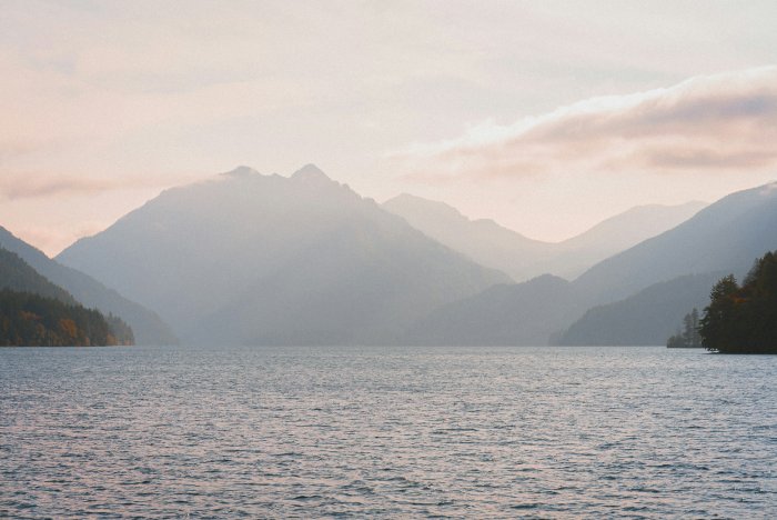 Misty mountains over a calm lake at dawn