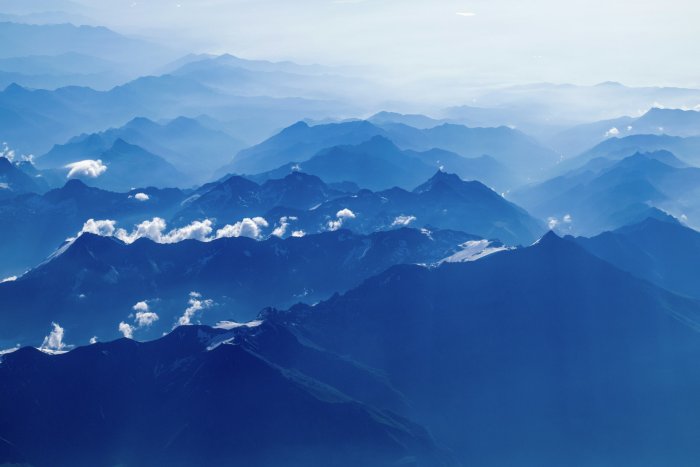 Aerial view of layered blue mountains and clouds