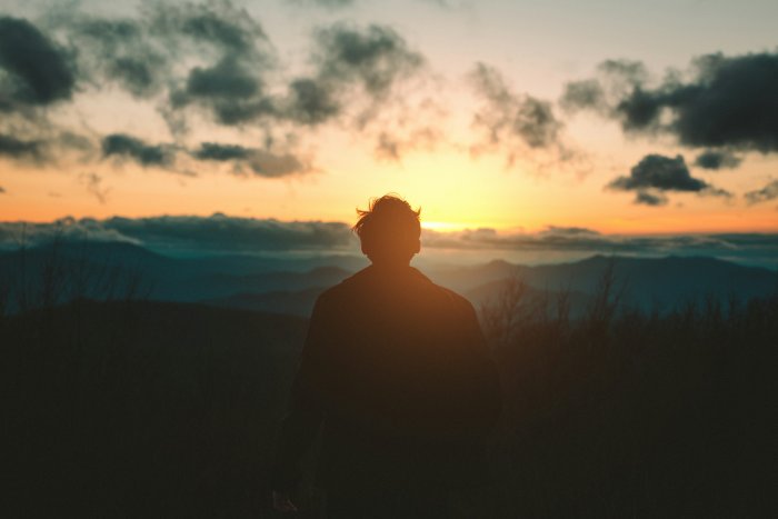 Man watching sunset over mountains