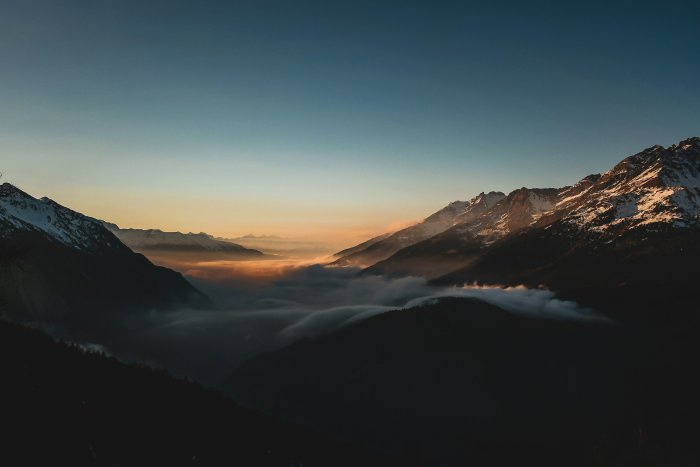 Mountain range at sunrise with clouds below