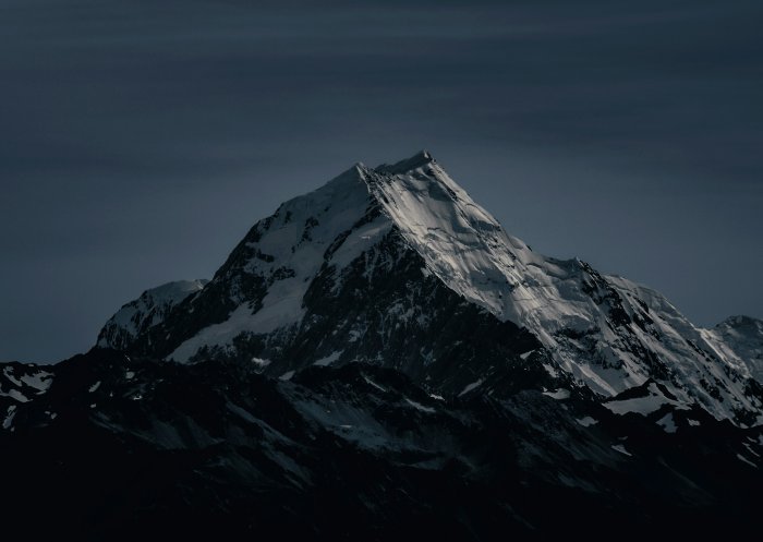 Snow-covered mountain peak under a dark sky