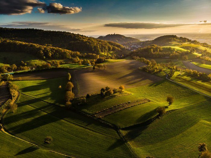 Aerial view of rolling hills and fields at sunset