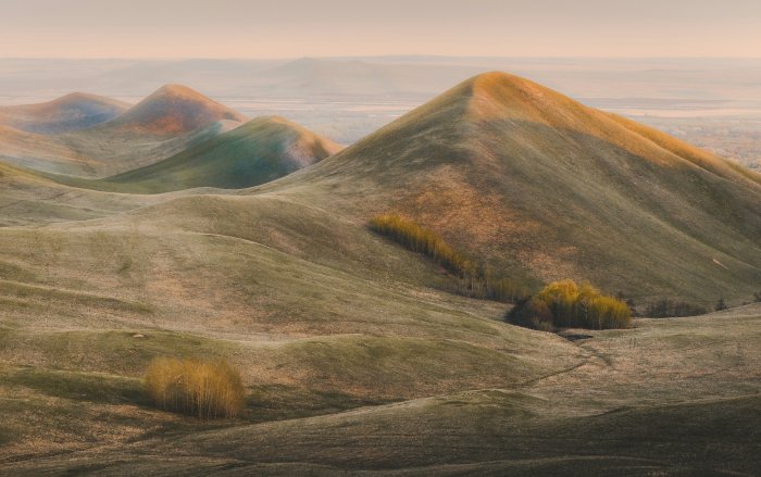 Rolling Hills and Distant Mountains at Sunrise