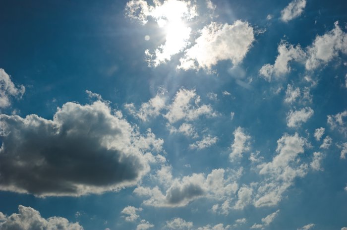 Sunlight shining through clouds in a blue sky