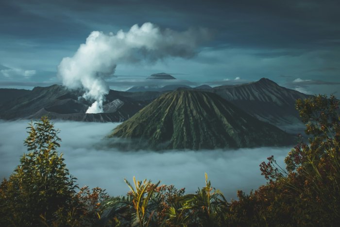 Volcanoes emerge from clouds at sunrise