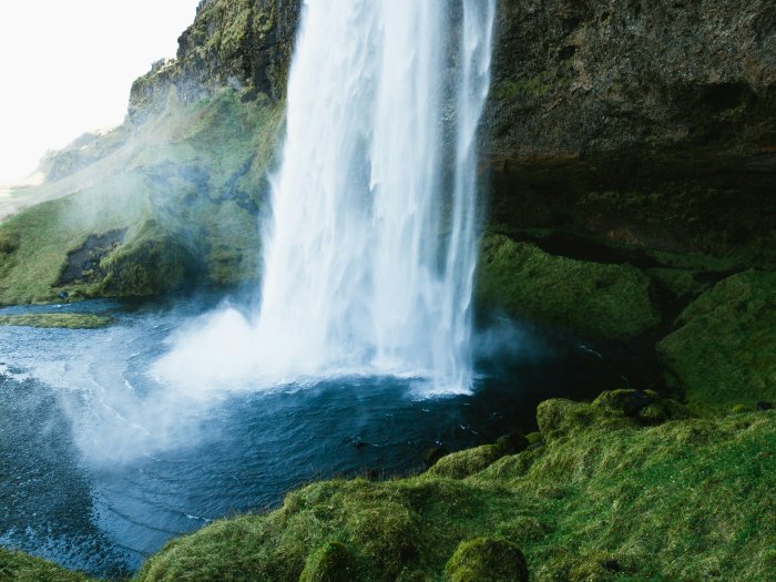 Powerful waterfall cascading into a dark pool