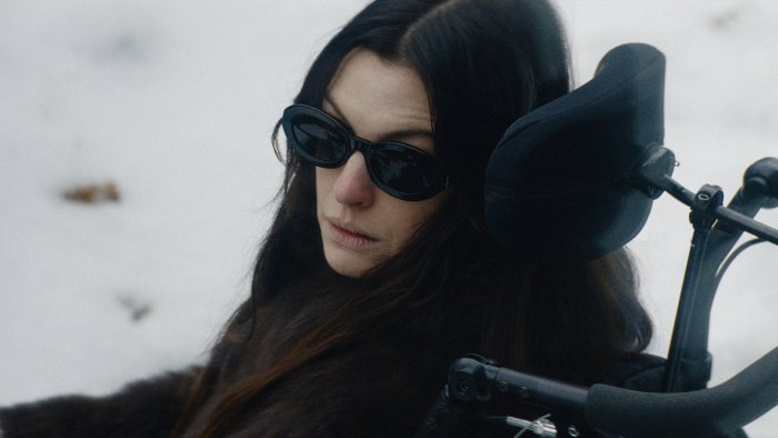 Woman in wheelchair wearing sunglasses in snow