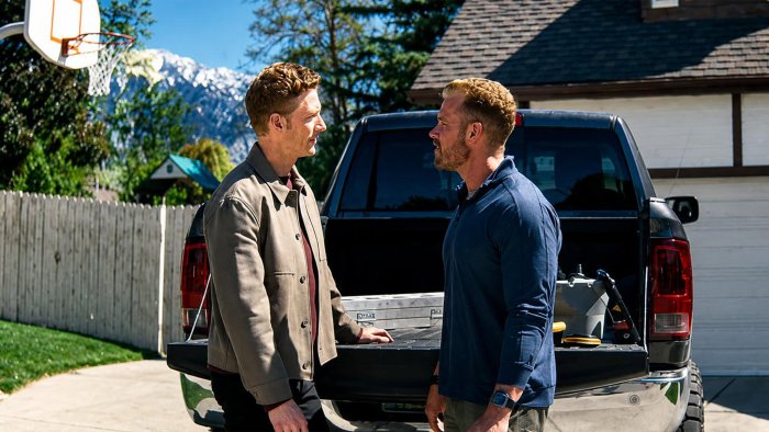 Two men talking by a pickup truck