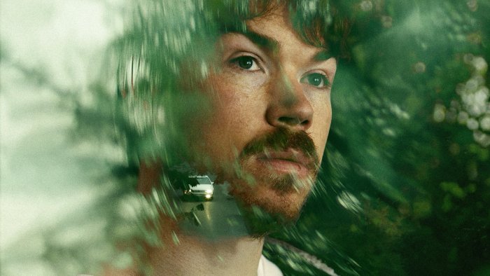 Man looking out a car window with nature overlay
