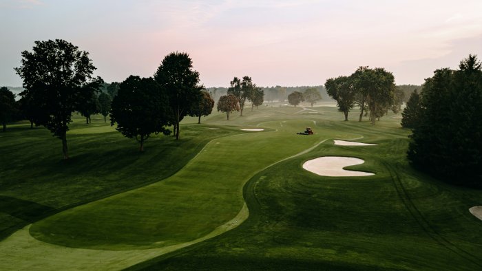 Golf course with trees and a lawn mower
