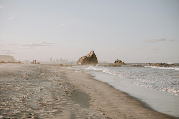 Beach with rocks and city skyline in the distance