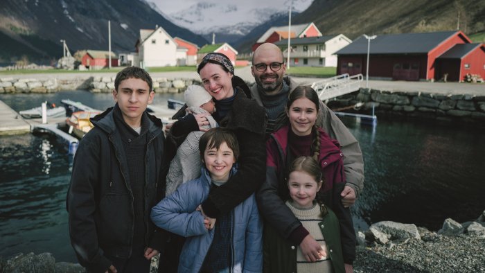 Family posing in front of a Norwegian village
