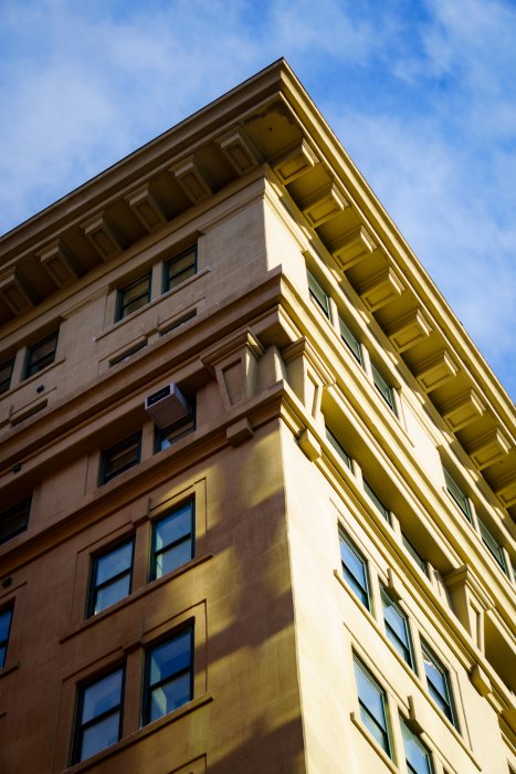 Corner of a tan building with blue sky