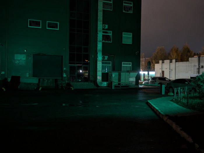 Dark industrial area at night with cars parked