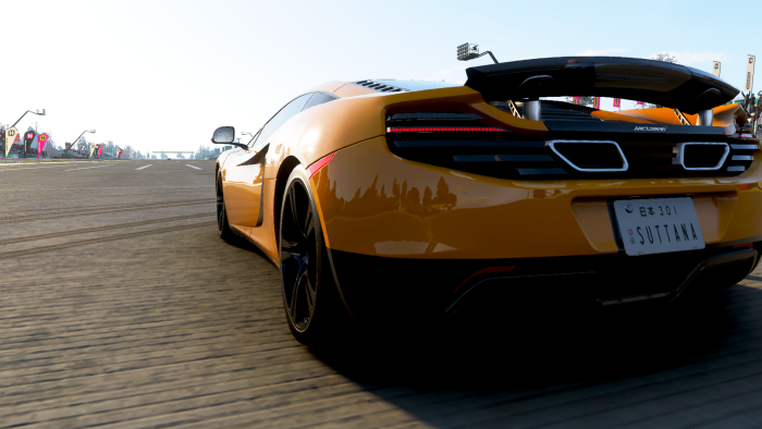 Orange McLaren sports car on a race track